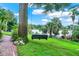 Charming backyard with a swing and serene water view, surrounded by lush greenery and mature trees at 840 2Nd St, Clermont, FL 34711