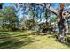 Expansive backyard featuring a lush lawn, mature trees draped with Spanish moss, and scenic lake views at 840 2Nd St, Clermont, FL 34711