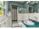 Well-lit bathroom featuring vintage green tile with a shower, vanity, and updated fixtures at 840 2Nd St, Clermont, FL 34711