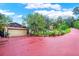 Wide driveway leading to the garage, complemented by lush landscaping and potted plants at 840 2Nd St, Clermont, FL 34711