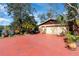 Spacious home driveway leading to garage with mature trees and waterfront views at 840 2Nd St, Clermont, FL 34711