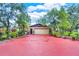 Wide driveway leading to the garage, complemented by lush landscaping and potted plants at 840 2Nd St, Clermont, FL 34711