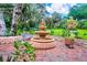 Stunning multi-tiered fountain surrounded by lush landscaping and brick pavers, creating a serene outdoor oasis at 840 2Nd St, Clermont, FL 34711