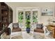 Cozy sitting area with white wicker furniture, offering views of the lush outdoor landscape and natural light at 840 2Nd St, Clermont, FL 34711