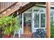 Exterior entrance to the bright sunroom featuring tile flooring, and several windows overlooking a lush garden at 840 2Nd St, Clermont, FL 34711