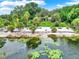 Picturesque waterfront view featuring a sandy beach, mature trees, and a tranquil pond with lily pads at 840 2Nd St, Clermont, FL 34711