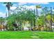 Lush garden entrance leading to a serene backyard oasis with tropical plants and swaying palm trees at 840 2Nd St, Clermont, FL 34711