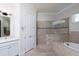 Luxurious bathroom showcasing a soaking tub, tiled shower, and elegant fixtures at 8682 Bridgeport Bay Cir, Mount Dora, FL 32757