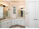 Bright bathroom featuring double vanities with granite countertops and recessed lighting at 8682 Bridgeport Bay Cir, Mount Dora, FL 32757