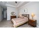 Comfortable bedroom with wood-look floors, side tables and a cozy, patterned bedspread at 8682 Bridgeport Bay Cir, Mount Dora, FL 32757