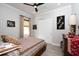 Cozy bedroom features a ceiling fan, window with curtains, and closet with sliding doors at 8682 Bridgeport Bay Cir, Mount Dora, FL 32757