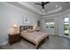 Cozy bedroom features a tray ceiling, wood-look flooring, and natural light from the window at 8682 Bridgeport Bay Cir, Mount Dora, FL 32757