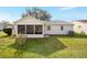 Backyard of home featuring a lawn and a screened-in porch at 901 Chula Ct, The Villages, FL 32159