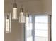 Modern pendant lighting fixtures with glass cylinders add style above the dining area at 901 Chula Ct, The Villages, FL 32159