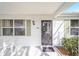 Inviting front porch with decorative door, shutters, and beautiful landscaping at 901 Chula Ct, The Villages, FL 32159