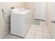 Well-lit laundry room with a white washer and dryer, neutral walls, and tile floor at 901 Chula Ct, The Villages, FL 32159