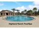 A large community pool with lap lanes, surrounded by palm trees and a clubhouse at 977 Timberview Rd, Clermont, FL 34715