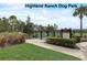 A fenced dog park with lush landscaping and seating, providing a safe space for pets to play at 977 Timberview Rd, Clermont, FL 34715