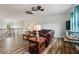 Open-concept living room with leather sofas, ceiling fans, and wood-look floors offering a welcoming atmosphere at 977 Timberview Rd, Clermont, FL 34715