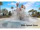 Fun splash zone with an exciting water feature, surrounded by lush greenery and palm trees at 977 Timberview Rd, Clermont, FL 34715