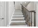 Elegant staircase featuring decorative wrought iron railings and modern gray treads at 977 Timberview Rd, Clermont, FL 34715