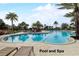 Large, inviting outdoor swimming pool with a sunbathing area and deck chairs, surrounded by lush palm trees at 977 Timberview Rd, Clermont, FL 34715