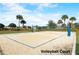 Well-maintained sand volleyball court with net and clear boundary lines, set in a landscaped area at 977 Timberview Rd, Clermont, FL 34715