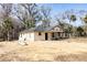 New construction home with gray roof, tan siding, and covered front porch, surrounded by natural landscape at Lot 19 Indian Estates Cr 423, Lake Panasoffkee, FL 33538