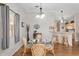 Dining area featuring a glass table, wood floors, and a view into the kitchen at 2277 Whisper St, The Villages, FL 32162