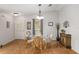 Bright dining room with wood floors, modern light fixture, and decorative shelving and cabinet at 2277 Whisper St, The Villages, FL 32162