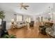 Open-concept living room with ceiling fan, wood-look flooring, and lots of natural light at 2277 Whisper St, The Villages, FL 32162