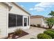 Close-up of a home's screened entrance, tidy landscaping, and proximity to the garage at 2277 Whisper St, The Villages, FL 32162