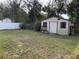 Large backyard featuring a storage shed, a tidy lawn, and a perimeter fence at 100 W Idlewild Ave, Eustis, FL 32726