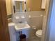 Cozy bathroom featuring classic white tile, vintage fixtures, and a storage cabinet at 100 W Idlewild Ave, Eustis, FL 32726