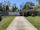 Charming single story home featuring mature trees, covered parking and a long driveway at 100 W Idlewild Ave, Eustis, FL 32726