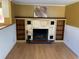 Living room features a brick fireplace, wooden mantel, and built in shelves at 100 W Idlewild Ave, Eustis, FL 32726