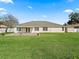 Expansive back yard features lush lawn, patio area, and secure vinyl perimeter fence at 10230 Barrington Ct, Leesburg, FL 34788