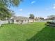 Large, well-maintained back yard featuring lush grass, a paver patio, and white vinyl fencing at 10230 Barrington Ct, Leesburg, FL 34788