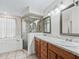 Bright bathroom featuring dual sinks, a glass enclosed shower, and separate soaking tub at 10230 Barrington Ct, Leesburg, FL 34788