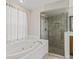 Bright bathroom featuring a tiled shower with glass door enclosure and separate soaking tub at 10230 Barrington Ct, Leesburg, FL 34788