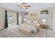 Cozy bedroom featuring a king bed, neutral décor, and sliding glass doors to the lanai at 10230 Barrington Ct, Leesburg, FL 34788