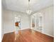 A dining room with hardwood floors, a modern chandelier, and an open archway at 10230 Barrington Ct, Leesburg, FL 34788