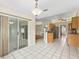 A dining room with tile floors, a sliding door and an open view of the kitchen at 10230 Barrington Ct, Leesburg, FL 34788