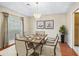 Elegant dining room with hardwood floors, chandelier, table setting, and a large window providing natural light at 10230 Barrington Ct, Leesburg, FL 34788