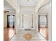 Bright foyer with tiled floor, arched entryway, and view into two rooms with hardwood floors and natural light at 10230 Barrington Ct, Leesburg, FL 34788