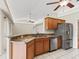 Bright kitchen featuring stainless appliances, wood cabinetry and breakfast bar at 10230 Barrington Ct, Leesburg, FL 34788