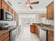 An open kitchen with stainless steel appliances, wooden cabinets and white tile flooring at 10230 Barrington Ct, Leesburg, FL 34788