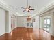 Spacious living room with hardwood floors and a ceiling fan opens to the kitchen at 10230 Barrington Ct, Leesburg, FL 34788