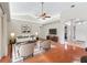 Cozy living room with hardwood floors, ceiling fan, and vaulted ceiling at 10230 Barrington Ct, Leesburg, FL 34788