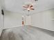 Carpeted main bedroom featuring a ceiling fan, ensuite bathroom and a large window at 10230 Barrington Ct, Leesburg, FL 34788